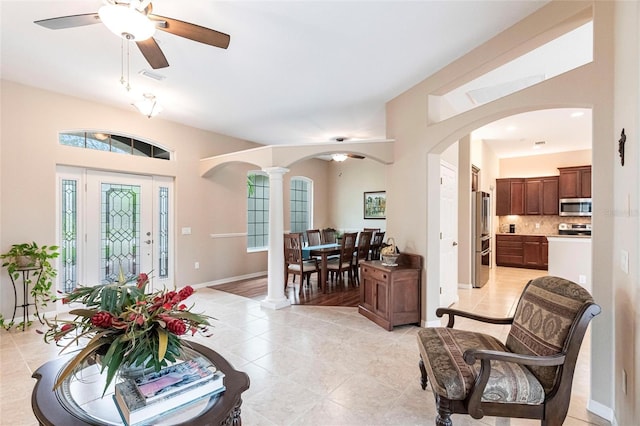 tiled foyer with ceiling fan and ornate columns