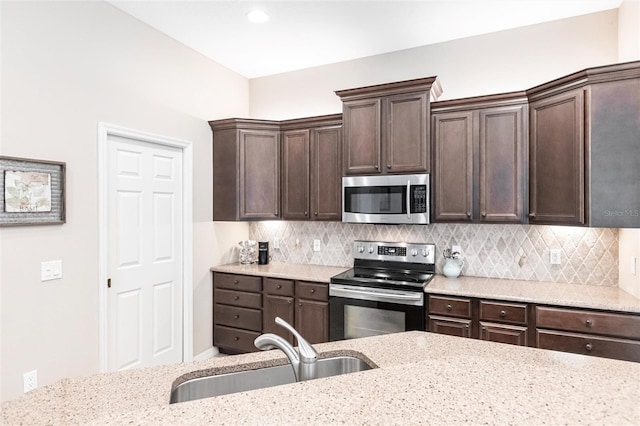 kitchen with decorative backsplash, stainless steel appliances, and light stone counters