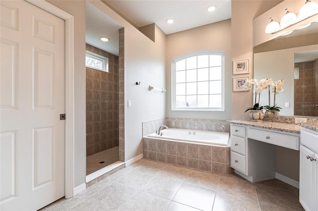 bathroom with plus walk in shower, vanity, and tile patterned flooring