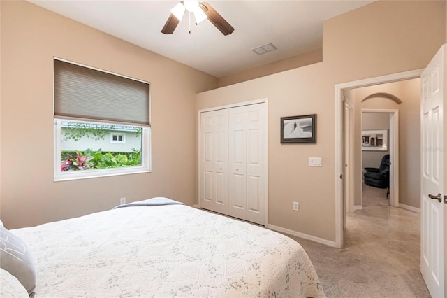 bedroom featuring ceiling fan, a closet, and light colored carpet