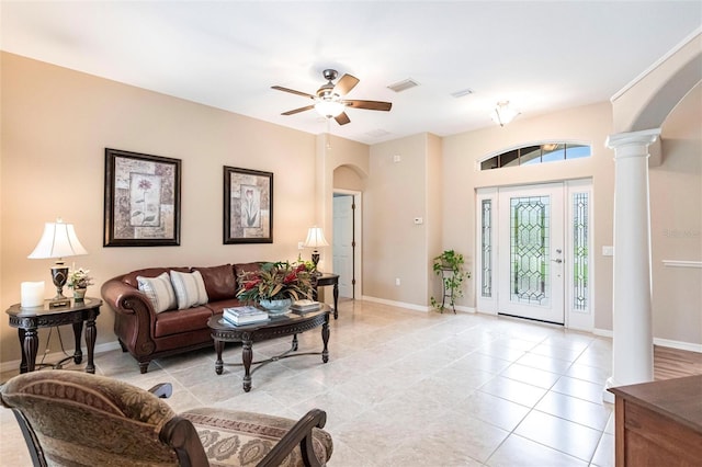 tiled living room featuring ceiling fan and decorative columns