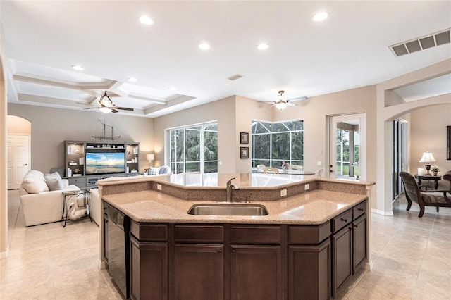 kitchen with ceiling fan, sink, an island with sink, and dark brown cabinetry