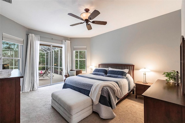 carpeted bedroom featuring ceiling fan, multiple windows, and access to exterior