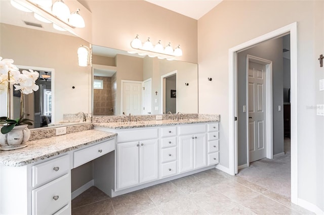 bathroom featuring vanity, tile patterned flooring, and tiled shower