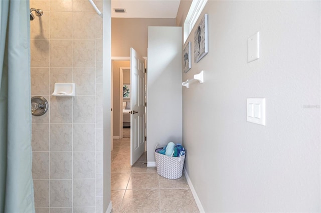 bathroom with curtained shower and tile patterned floors