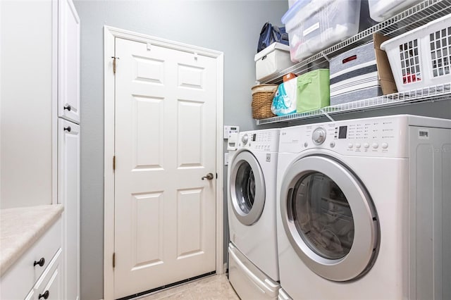 laundry area featuring cabinets, separate washer and dryer, and light tile patterned flooring