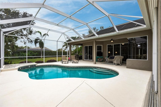 view of pool featuring a patio, ceiling fan, and glass enclosure