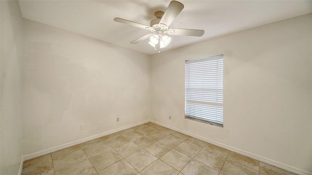 empty room with ceiling fan and light tile patterned flooring