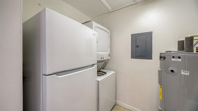 washroom featuring light tile patterned floors, electric water heater, electric panel, and stacked washer and clothes dryer