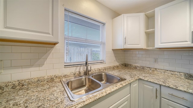 kitchen with white cabinets, tasteful backsplash, and sink