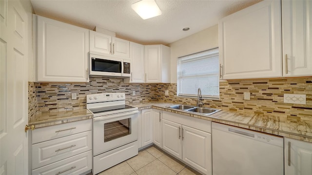 kitchen featuring light tile patterned floors, tasteful backsplash, white appliances, white cabinets, and sink