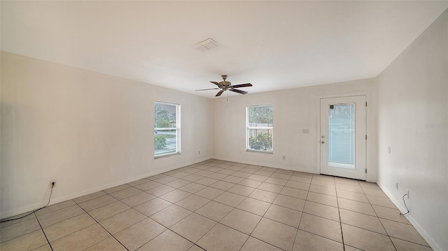 tiled empty room featuring ceiling fan