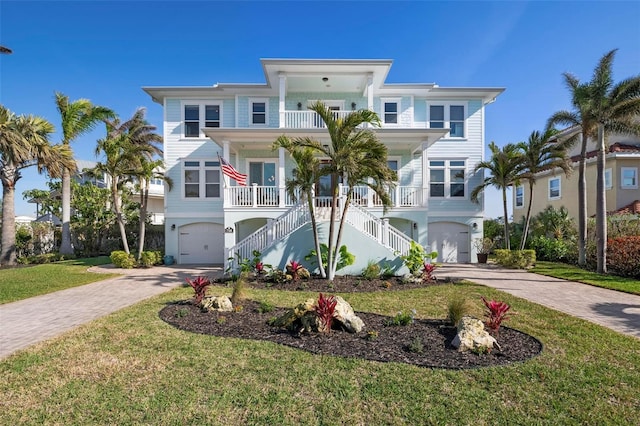 view of front of property featuring a garage, a front lawn, french doors, and a porch