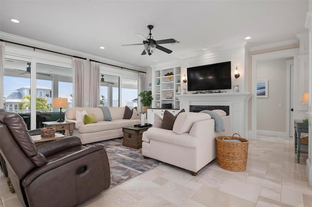 living area featuring baseboards, a premium fireplace, recessed lighting, ceiling fan, and crown molding