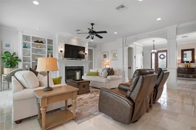 living room featuring visible vents, ceiling fan with notable chandelier, a high end fireplace, arched walkways, and decorative columns