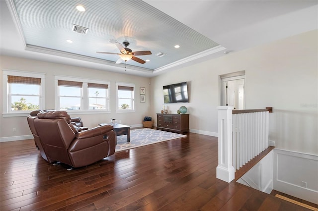 living room featuring visible vents, a raised ceiling, baseboards, and hardwood / wood-style flooring