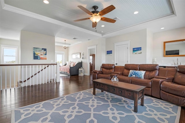 living area featuring recessed lighting, ornamental molding, a tray ceiling, and wood-type flooring