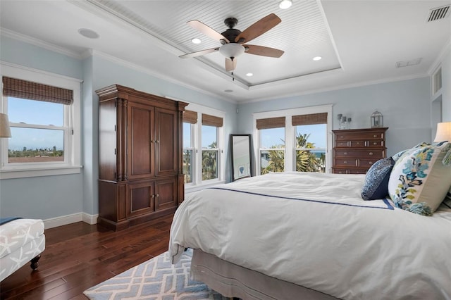 bedroom with visible vents, a raised ceiling, dark wood-type flooring, and crown molding