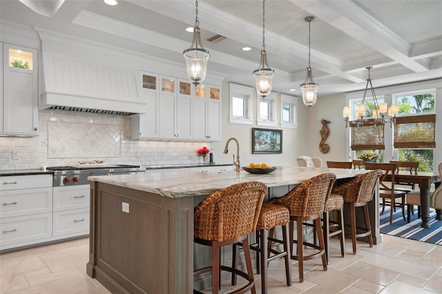 kitchen featuring decorative backsplash, beam ceiling, custom range hood, and coffered ceiling