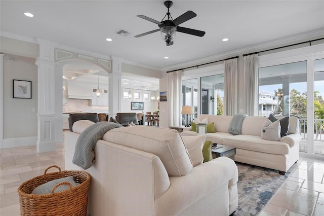 living room featuring visible vents, plenty of natural light, ornamental molding, and decorative columns