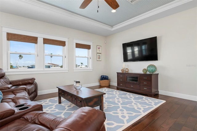 living room featuring dark wood finished floors, a raised ceiling, baseboards, and ornamental molding