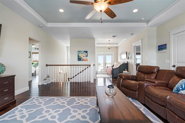 living area with french doors, a raised ceiling, dark wood-type flooring, and crown molding