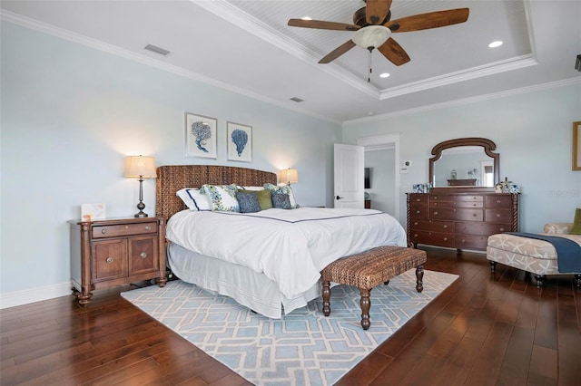 bedroom featuring dark wood finished floors, a raised ceiling, visible vents, and ornamental molding