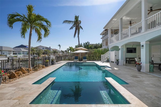 view of swimming pool featuring a pool with connected hot tub, a fenced backyard, a ceiling fan, and a patio area