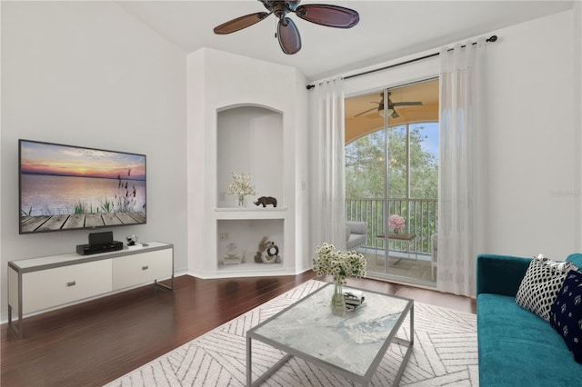 living room with ceiling fan and dark hardwood / wood-style flooring