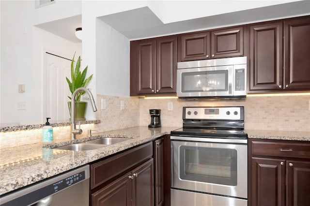 kitchen with dark brown cabinetry, backsplash, sink, and appliances with stainless steel finishes