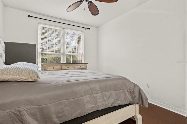 bedroom with dark hardwood / wood-style flooring and ceiling fan