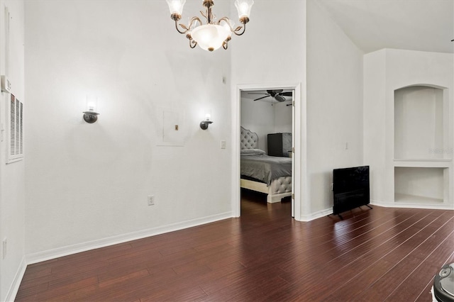 interior space with dark hardwood / wood-style flooring and ceiling fan with notable chandelier