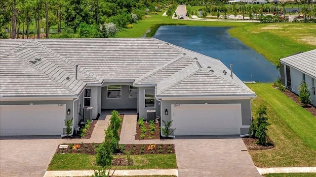 view of front of home featuring a water view, central air condition unit, and a garage