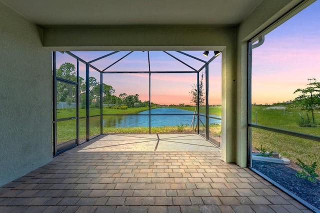 unfurnished sunroom featuring a water view