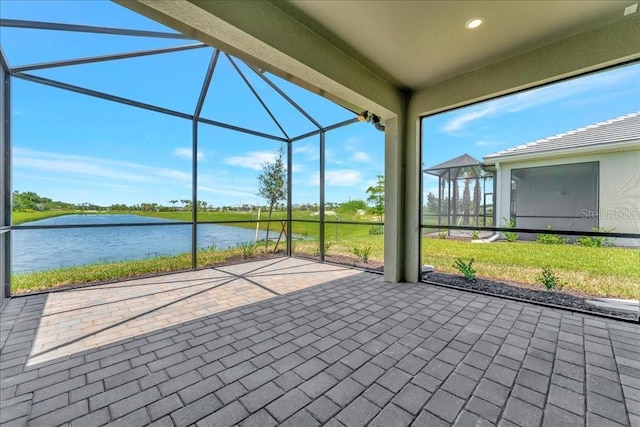 view of patio / terrace with a lanai and a water view