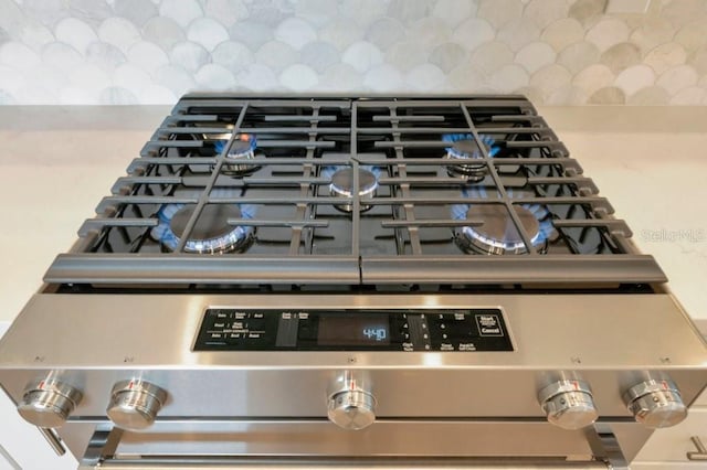 interior details with stainless steel range oven and tasteful backsplash