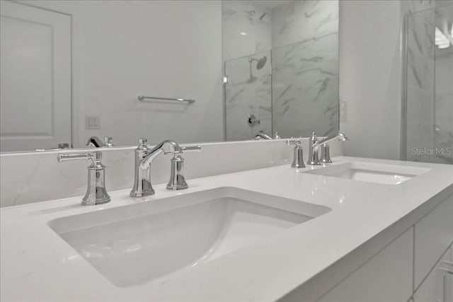 bathroom featuring a shower with door and vanity