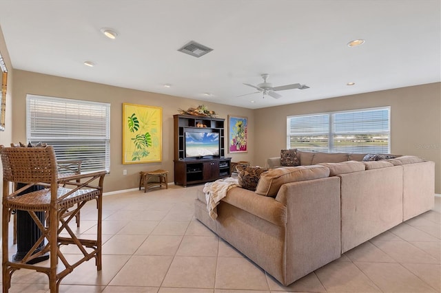 living room featuring light tile patterned floors, a ceiling fan, visible vents, and baseboards