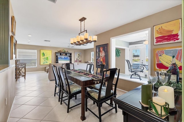 dining room with light tile patterned flooring, visible vents, ceiling fan with notable chandelier, and baseboards