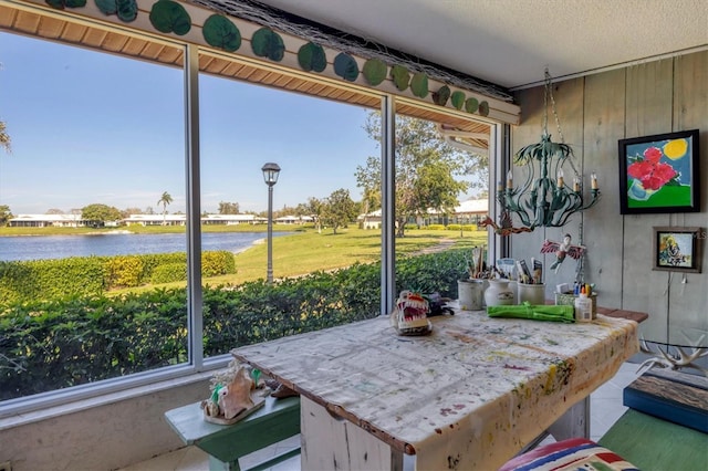 sunroom featuring a wealth of natural light and a water view