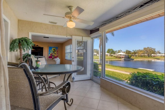 sunroom with visible vents, a ceiling fan, and a water view