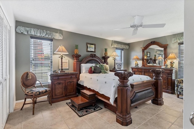 bedroom featuring light tile patterned flooring, a ceiling fan, and a textured ceiling