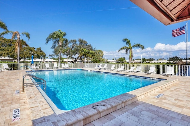 community pool with a patio and fence