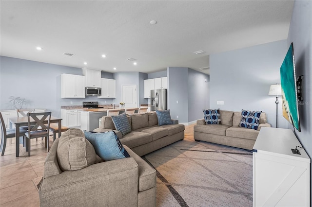 living area with light tile patterned floors, visible vents, and recessed lighting