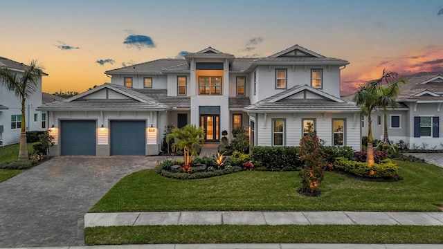 view of front of property with a garage and a lawn