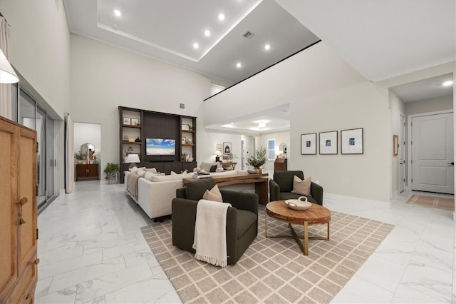 living room featuring a high ceiling and a tray ceiling