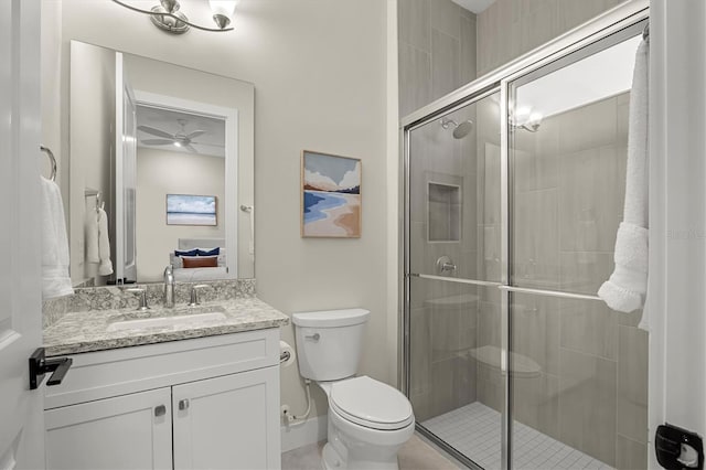 bathroom with toilet, an enclosed shower, ceiling fan, and vanity