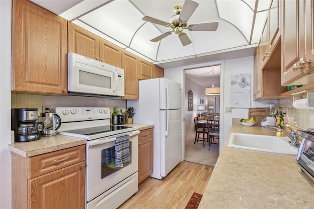 kitchen with sink, light wood-type flooring, ceiling fan, white appliances, and backsplash