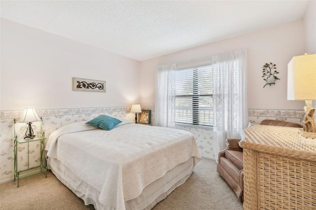 bedroom with light colored carpet and a textured ceiling