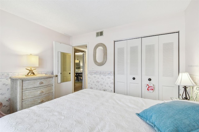 bedroom with a textured ceiling and a closet